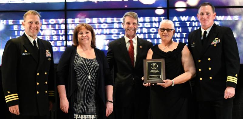 DAHLGREN, Va. (May 10, 2019) – Delois Clarke holds the Employee Development Award moments after receiving it from Naval Surface Warfare Center Dahlgren Division (NSWCDD) leadership at the command’s annual honor awards ceremony. Clarke was recognized for her exemplary execution as a leader across the organization. Her mentorship and persistence has led to a continuous pipeline of highly skilled personnel, enabling the successful maintenance of a key national capability. Standing left to right: NSWCDD Dam Neck Activity Commanding Officer Cmdr. Andrew Hoffman; NSWCDD Deputy Technical Director Angela Beach; U.S. Rep. Rob Wittman; Clarke; and NSWCDD Commanding Officer Cmdr. Stephen ‘Casey’ Plew.  (U.S. Navy photo/Released)