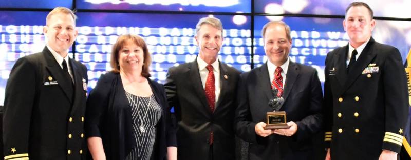 DAHLGREN, Va. (May 10, 2019) – Brian Seay holds the John Adolphus Dahlgren Award moments after receiving it from Naval Surface Warfare Center Dahlgren Division (NSWCDD) leadership at the command’s annual honor awards ceremony. The award was granted to Seay for his innovative technical contributions and proven ability as a director. Seay was recognized for his ability to organize, motivate, develop strategies and lead teams to meet complex combat system goals while adjusting to continuously changing requirements, schedules and budgets. Standing left to right: NSWCDD Dam Neck Activity Commanding Officer Cmdr. Andrew Hoffman; NSWCDD Deputy Technical Director Angela Beach; U.S. Rep. Rob Wittman; Seay; and NSWCDD Commanding Officer Cmdr. Stephen ‘Casey’ Plew.  (U.S. Navy photo/Released)