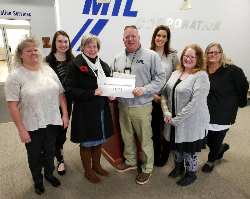 Members of the MIL Cares Program Team presenting Jolanda Campbell, Greenwell's Executive Director, with their gift. Pictured are (from left), Debora Vincent, Erin Tice, Jolanda Campell, Ricky Chesser, Betsey Channell, Shannon Mitchell and Carol Coffren. Members of the team not pictured include. Arlene Fenwick, Ashlee Dalrymple, Megan Warren Amber Abell and Patrick DeBoe.