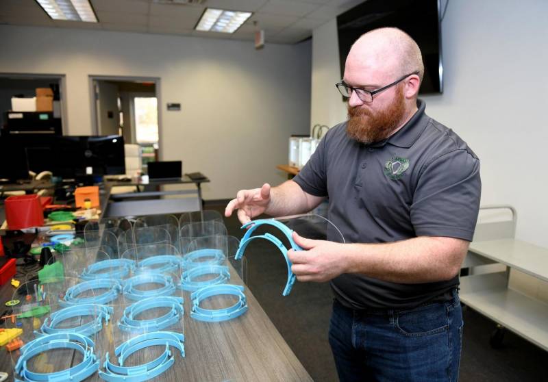 David Hamm, an engineer with Mechanisms and Modeling and Simulation Lab at NAS Patuxent River inspects a 3-D printed face shield March 28 as part of the COVID-19 response effort. FEMA asked the Navy to help produce personal protective equipment using additive manufacturing. (U.S. Navy photo by Peter Fitzpatrick)