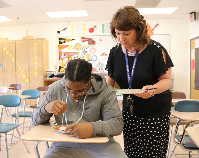 Henry E. Lackey High School Kathy Perriello, right, was named Principal of the Year for Charles County Public Schools. Among other achievements, Perriello reinvigorated the school's Key Club. During a recent club meeting Perriello helped students, including senior Xavier Oliver, paint kindness rocks for donation to the Hospice House of Charles County. 