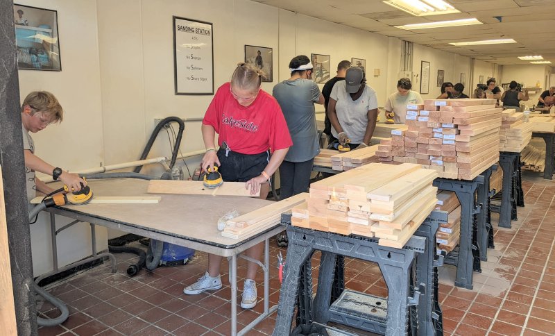 A group of volunteers constructing the bed frames.