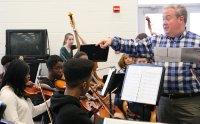 Stephen Czarkowski, a conductor and cellist, right, works with strings students at Henry E. Lackey High School during a recent music clinic.