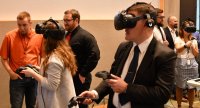 KING GEORGE, Va. (May 22, 2019) - Three attendees engage in a virtual reality visualization of Navy ships - inside and out - at the first annual Modeling and Simulation Summit sponsored by the Naval Surface Warfare Center Dahlgren Division. Two engineers fly around the topside of Navy ships via virtual reality while a third explores the interior of an amphibious transport dock ship's pilot house.  The event - held at the University of Mary Washington Dahlgren campus - focused on modeling and simulation capabilities in areas such as model-based systems engineering, mission engineering and analysis, theater and force level modeling, computational physics, optimization, virtual reality and 3D scanning. (U.S. Navy Photo/Released)