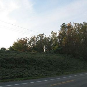 Cross in back of a cemetary on a main road