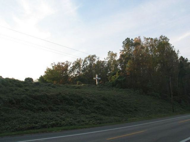 Cross in back of a cemetary on a main road